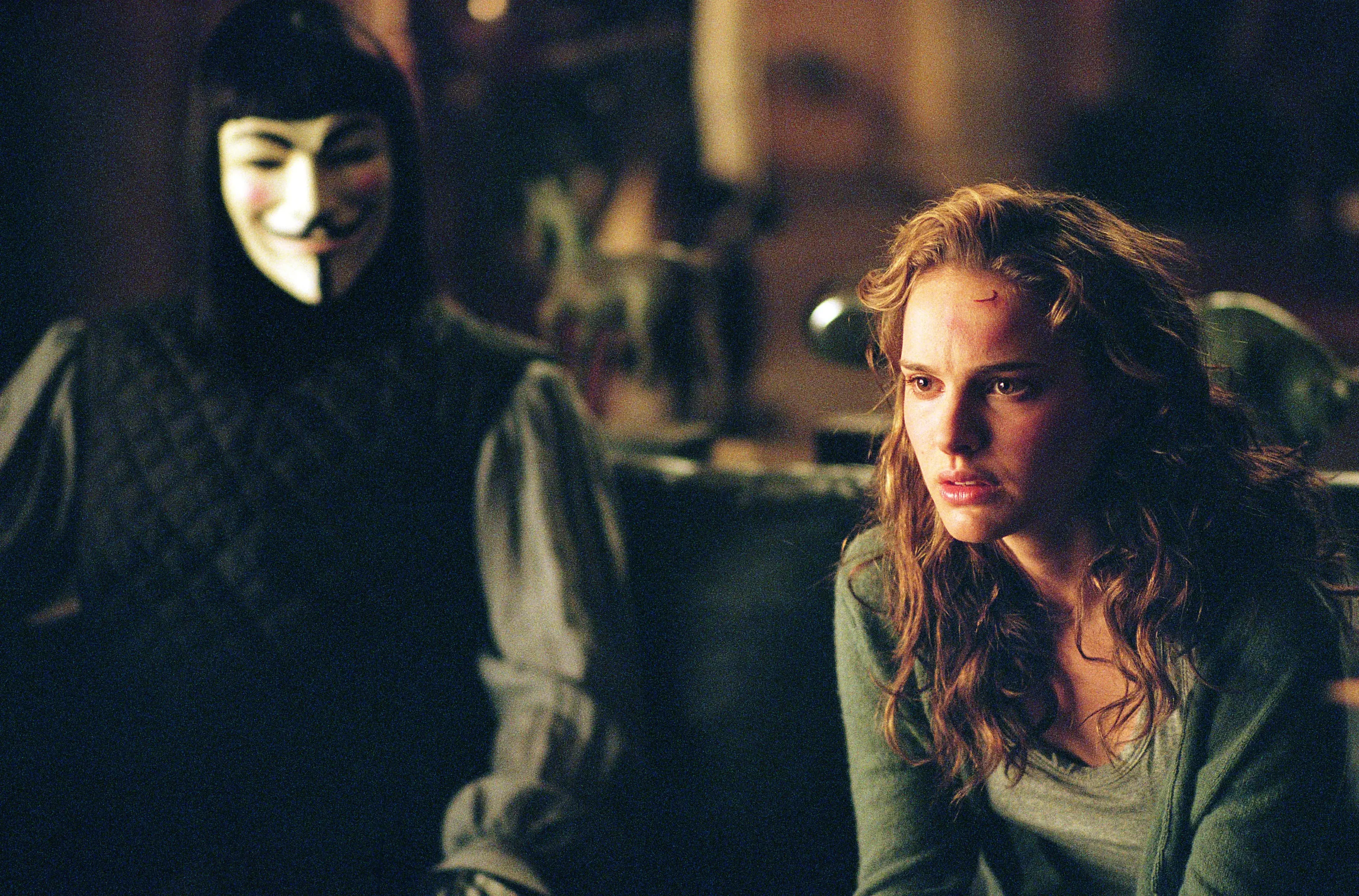 Filmszene, Guy-Fawkes-Maske, grüne Strickjacke, langes braunes Haar